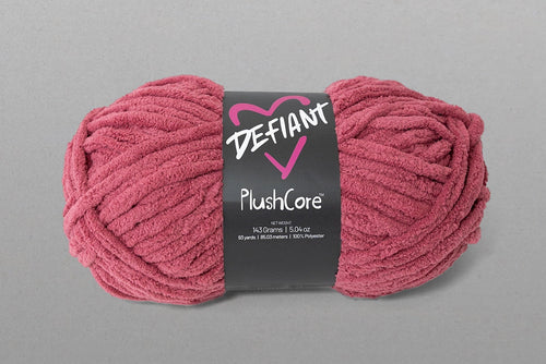 Pink skein of yarn with a 'Defiant' label on a gray background