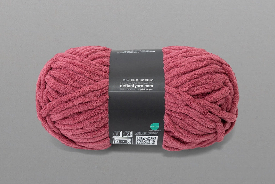 Pink skein of yarn with a label on a gray background