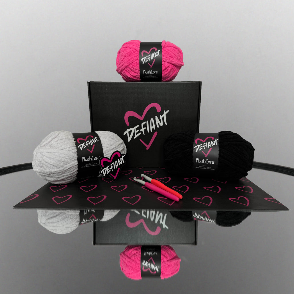 Yarn balls with Defiant branding on a reflective surface