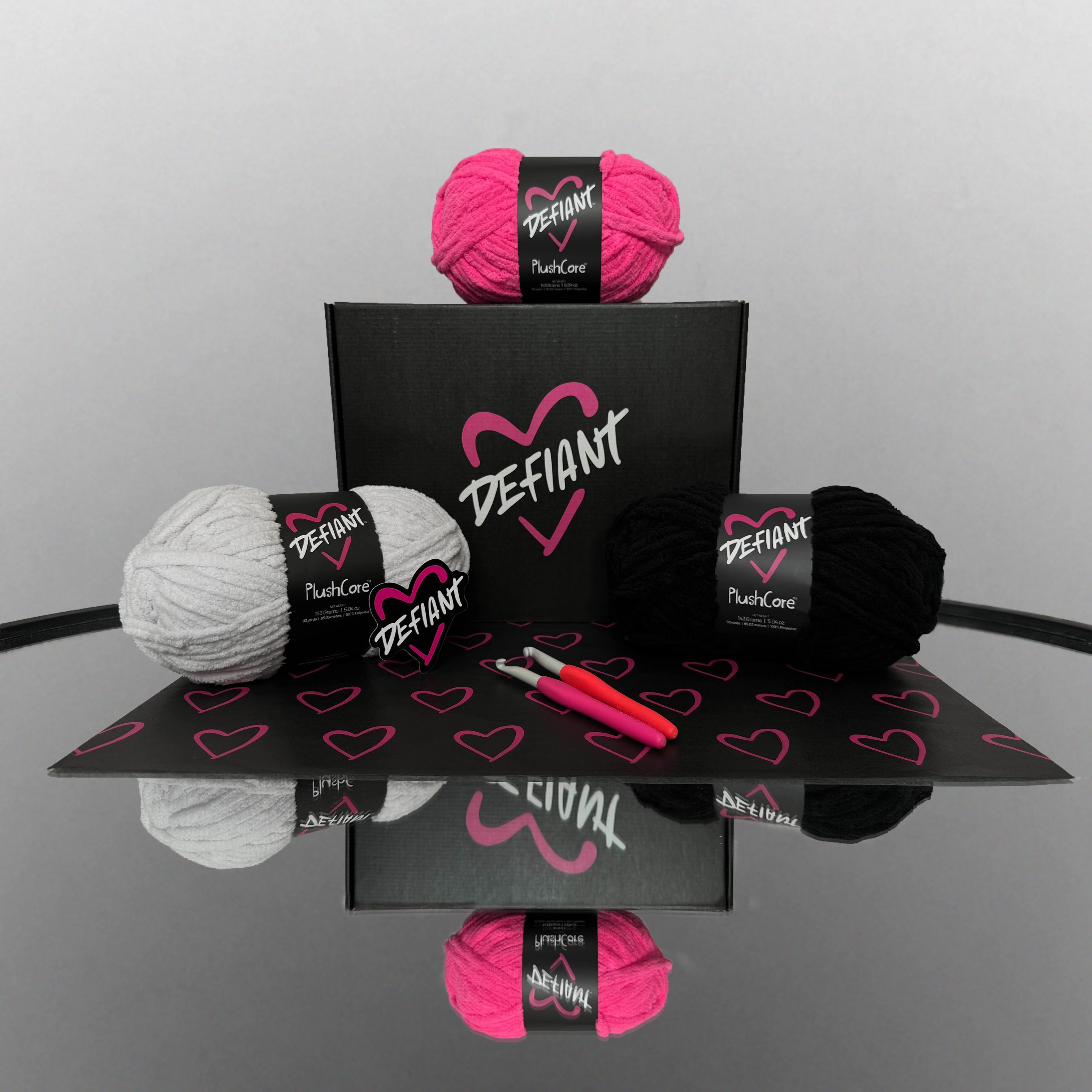 Yarn balls with Defiant branding on a reflective surface