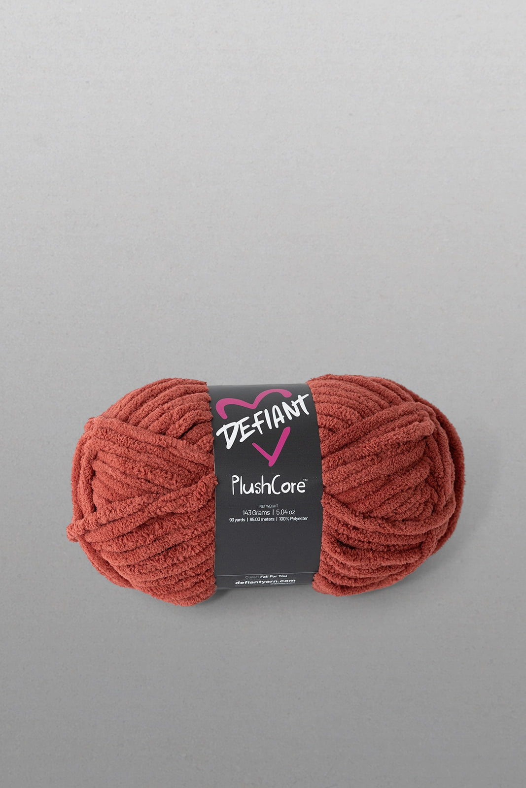 Ball of red yarn with a Defiant label on a gray background