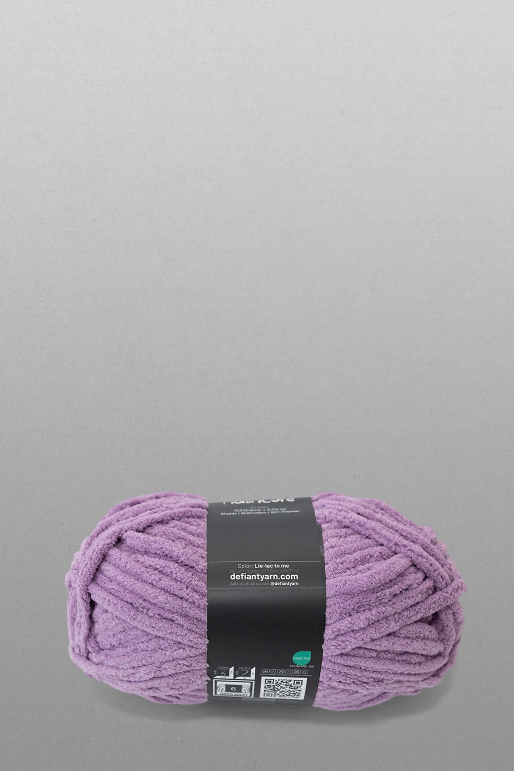 Purple yarn ball with a label on a gray background