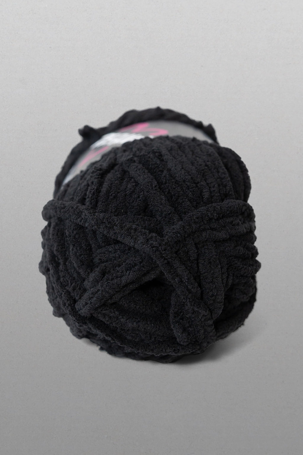 Black yarn ball on a gray background