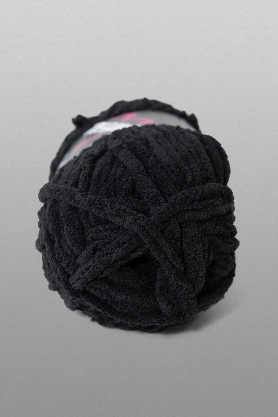 Black yarn ball on a gray background