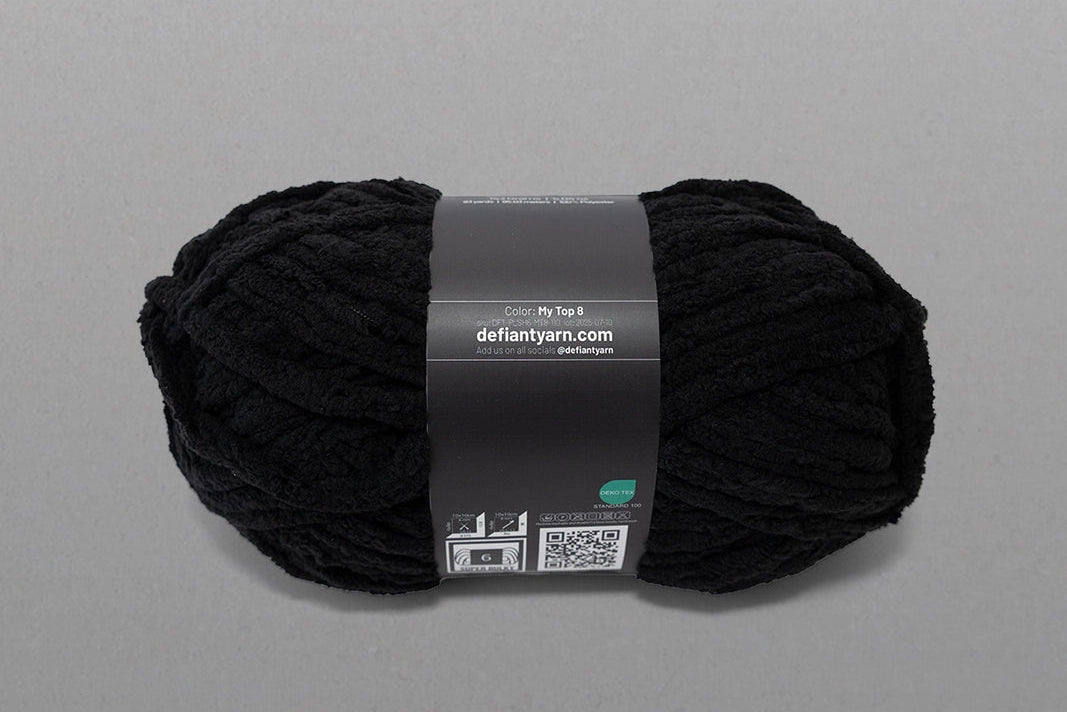 Black yarn ball with a label on a gray background