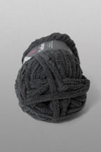 Ball of dark gray yarn on a light gray background
