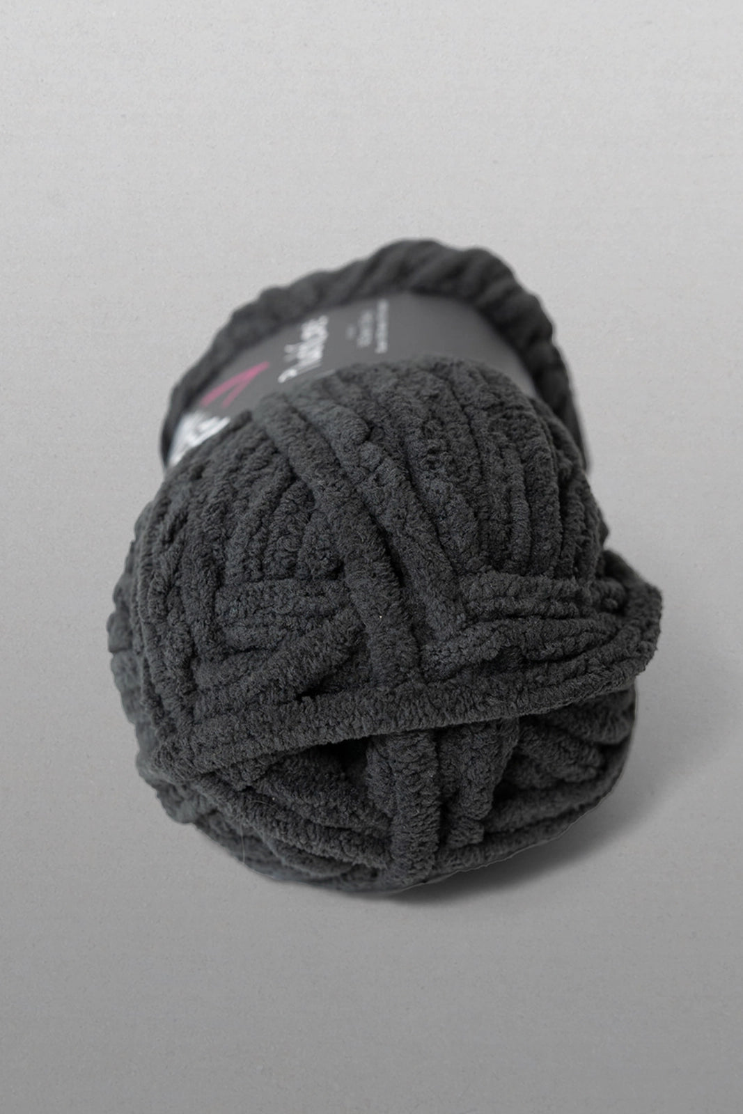 Ball of dark gray yarn on a light gray background