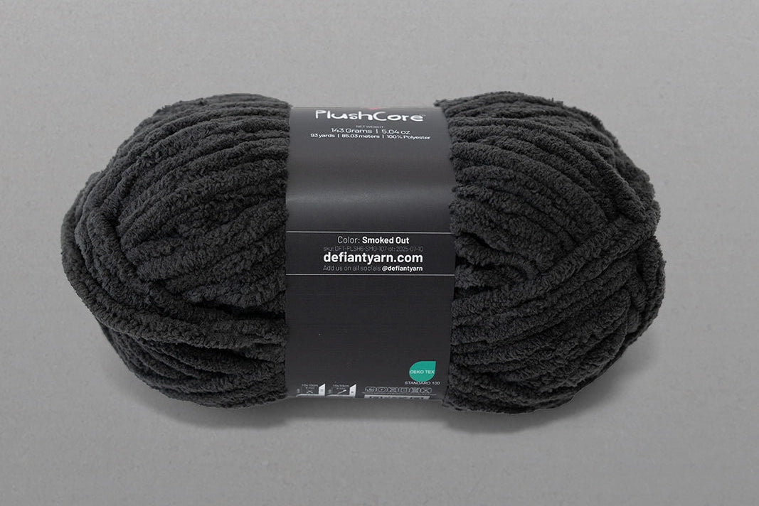 Black yarn ball with a label on a gray background