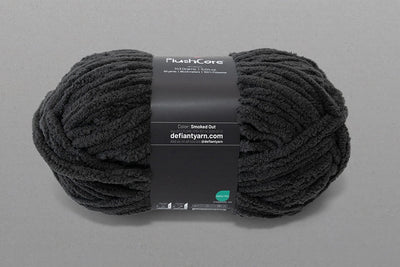 Black yarn ball with a label on a gray background