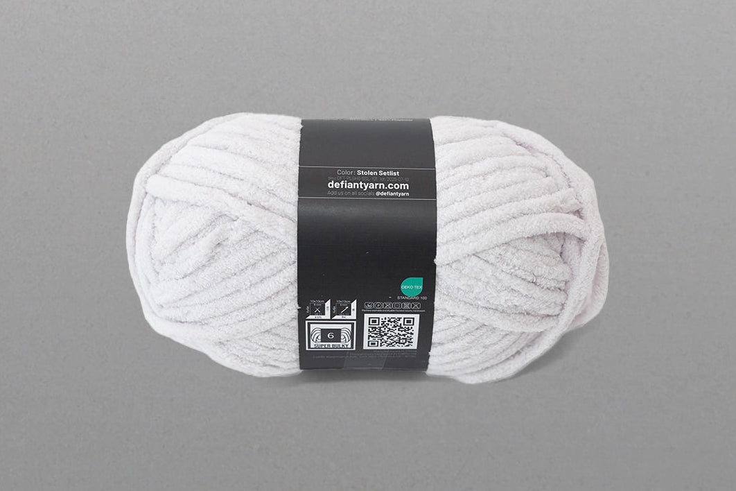 Ball of white yarn with a label on a gray background