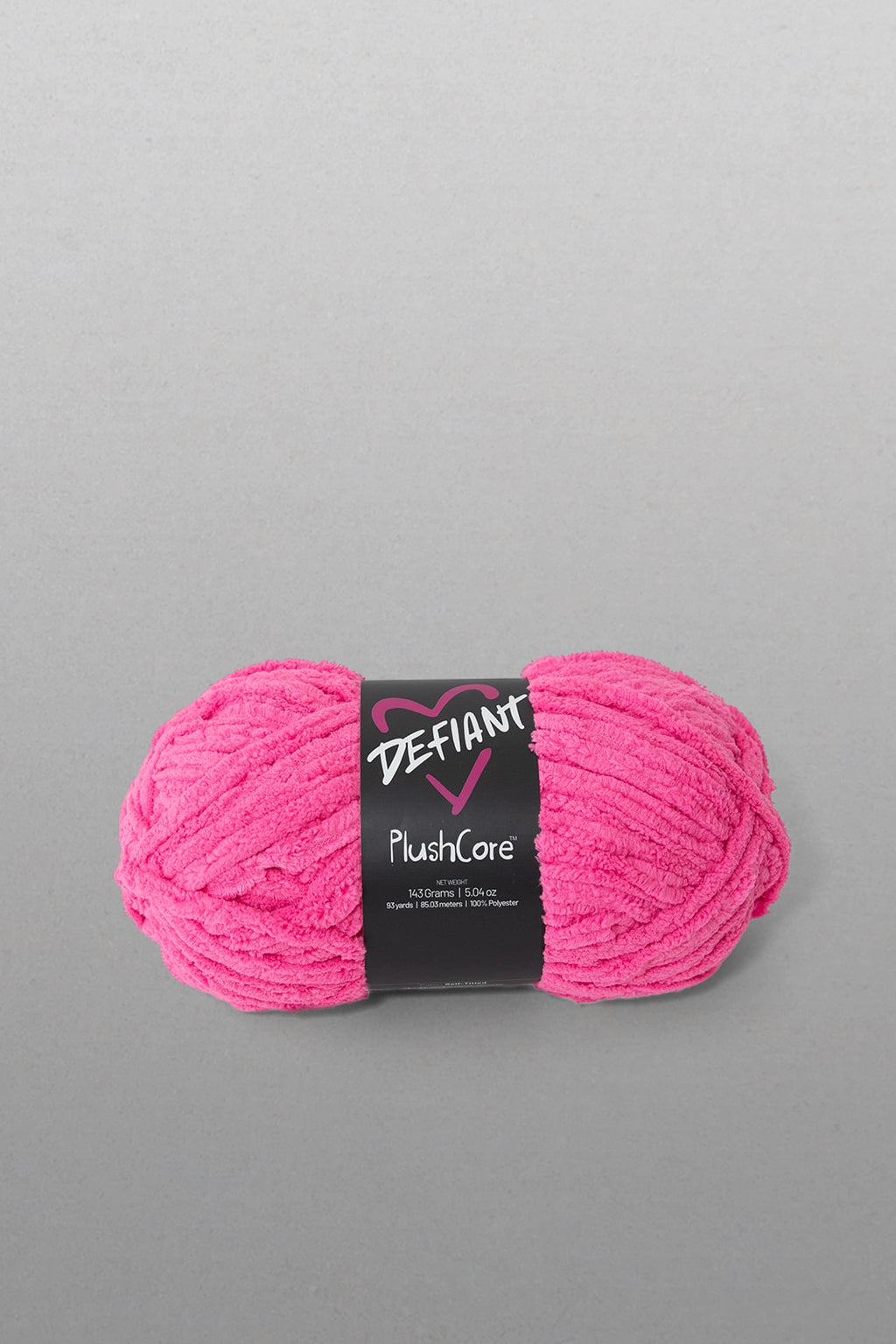 Pink skein of yarn with a black label on a gray background