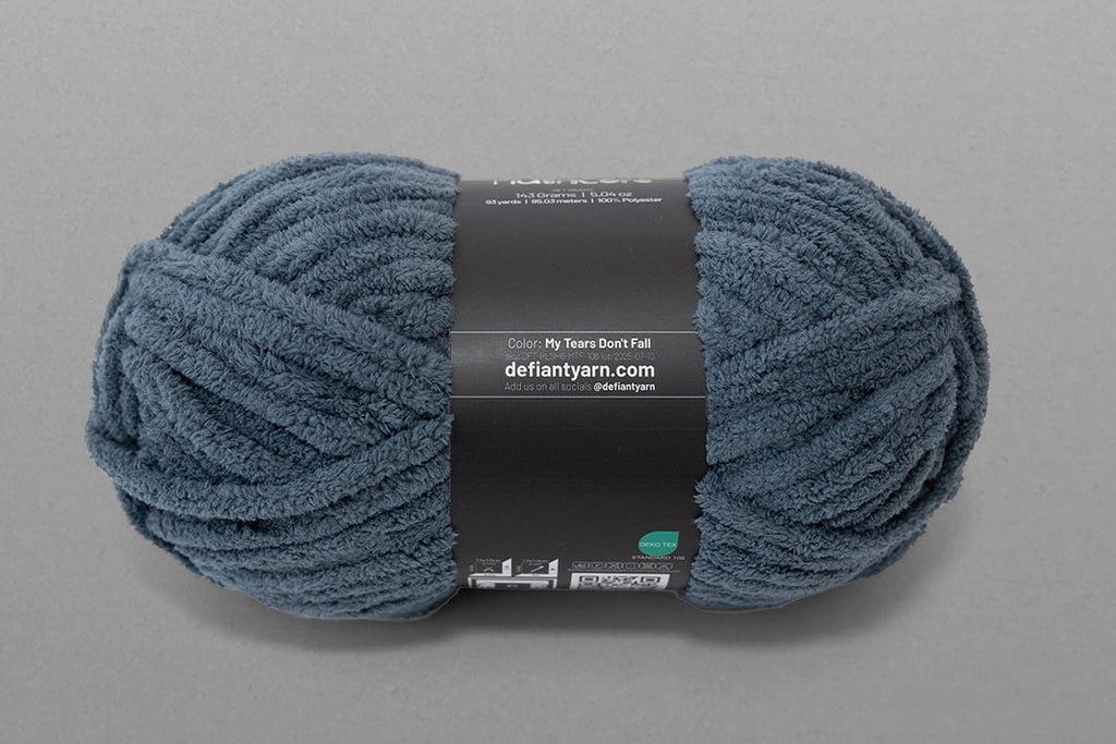 Blue skein of yarn with a label on a gray background
