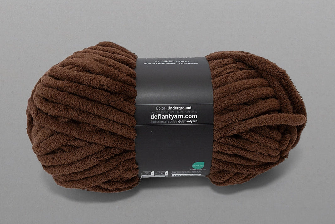 Brown skein of yarn with a label on a gray background